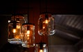 Retro vintage light bulbs inside empty DIY jar glasses as creative lamps hangings from the ceiling in house interior