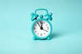 Retro vintage mint alarm clock on blue background. Time concept. Midday, midnight.