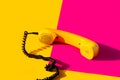 Retro vintage phone handset yellow pink red purple plastic orange disko background old style shadow 90 Royalty Free Stock Photo