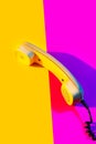 Retro vintage phone handset yellow pink red purple plastic orange disko background old style shadow 90 Royalty Free Stock Photo