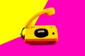 Retro vintage phone handset yellow pink red purple plastic orange disko background old style shadow 90 Royalty Free Stock Photo