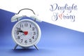 Retro vintage style white alarm clock on blue and white background with Daylight Saving sample text Royalty Free Stock Photo