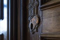 Retro vintage wooden door with brass copper keyhole. Old metal keyhole