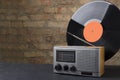 Retro vinyl record, radio player against old brick wall.Empty space for design Royalty Free Stock Photo