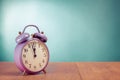 Retro violet alarm clock on the desk front mint green wall background Royalty Free Stock Photo