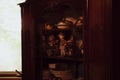 Retro Western dolls in wooden shelf with antique cutleries, teacups and plates