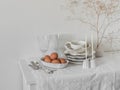 Retro white ceramic tableware, glasses, cutlery, eggs in a bowl on a light chest of drawers with a white tablecloth Royalty Free Stock Photo