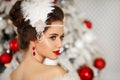 Retro woman Cristmas portrait. Elegant brunette lady with feather in wedding hairstyle, beauty makeup and ruby jewelry set wears Royalty Free Stock Photo