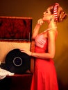 Retro woman with music vinyl record. Girl pin-up style wearing red dress. Royalty Free Stock Photo