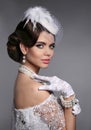 Retro woman portrait. Elegant lady with hairstyle, pearls jewelry set wears in white hat and lace gloves posing isolated on Royalty Free Stock Photo