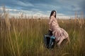 Retro woman is sitting in the field