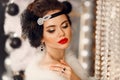 Retro woman in white fur coat. Cristmas portrait. Elegant lady with feather in wedding hairstyle, beauty makeup and diamond black Royalty Free Stock Photo