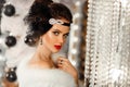 Retro woman in white fur coat. Cristmas portrait. Elegant lady with feather in wedding hairstyle, beauty makeup and diamond black Royalty Free Stock Photo