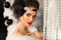 Retro woman in white fur coat. Cristmas portrait. Elegant lady with feather in wedding hairstyle, beauty makeup and diamond black Royalty Free Stock Photo