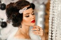 Retro woman in white fur coat. Cristmas portrait. Elegant lady with feather in wedding hairstyle, beauty makeup and diamond black Royalty Free Stock Photo