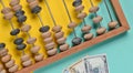 Retro wooden abacus, dollar bills on a colored paper background. top view.