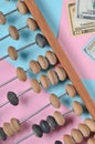 Retro wooden abacus, dollar bills on a colored paper background. top view.