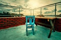 Retro wooden blue chair and a wooden table on the balcony with red brick walls Royalty Free Stock Photo
