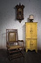 Retro wooden rocking chair, yellow cupboard and pendulum clock