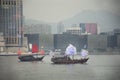 Retro wooden ship or Chinese junk boats for travelers people looking view of Hong Kong and Kowloon island at Victoria Harbour Royalty Free Stock Photo