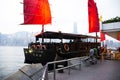 Retro wooden ship or Chinese junk boats for travelers people looking view of Hong Kong and Kowloon island at Victoria Harbour