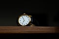 Retro wristwatch with Roman numerals on the dial on a wooden surface