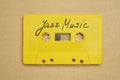 Retro yellow audio cassette tape with jazz music laying on the paper background.