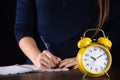 Retro yellow old clock and woman in background writing Royalty Free Stock Photo