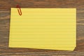 Retro yellow paper index cards stack with paper clip on wood desk Royalty Free Stock Photo