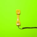 Retro yellow telephone tube on fluorescent green background - Minimal design Royalty Free Stock Photo