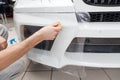 Retrofitting the car with a solid transparent protective film, the master glues the coating protecting the vehicles from scratches Royalty Free Stock Photo