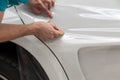 Retrofitting the car with a solid transparent protective film, the master glues the coating protecting the vehicles from scratches Royalty Free Stock Photo