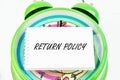 Return Policy written on the business card on the alarm clock Royalty Free Stock Photo