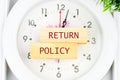 Return Policy written on the wooden blocks on the clock with hands Royalty Free Stock Photo