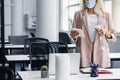 Return to work, workplace hygiene and new normal. Blond woman in business suit in protective mask with paper towel and Royalty Free Stock Photo