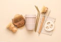 Reusable bathroom and kitchen items on a beige background. Natural cleaning brushes, Luffa scrubber, metal straws and a glass for Royalty Free Stock Photo