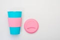 Reusable blue cup with pink silicone sleeve and lid for coffee, hot and cold drinks