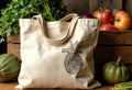 Reusable canvas bag with pineapple illustration surrounded by fresh vegetables Royalty Free Stock Photo