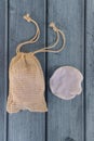 Reusable cotton make-up remover pad and eco bag on blue wooden background.