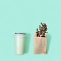 Reusable eco coffee cup and roasted coffee beans in paper package. Zero waste concept, flat lay Royalty Free Stock Photo