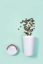 Reusable eco coffee cup with roasted coffee beans