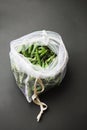 Reusable eco-friendly bag full of fresh seasonal pea pods on black background Royalty Free Stock Photo