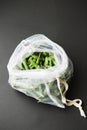 Reusable eco-friendly bag full of fresh seasonal pea pods on black background Royalty Free Stock Photo