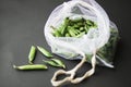 Reusable eco-friendly bag full of fresh seasonal pea pods on black background Royalty Free Stock Photo