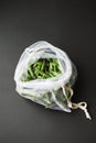 Reusable eco-friendly bag full of fresh seasonal pea pods on black background Royalty Free Stock Photo