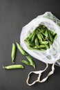 Reusable eco-friendly bag full of fresh seasonal pea pods on black background Royalty Free Stock Photo