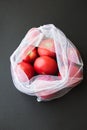 Reusable eco-friendly bag full of fresh seasonal tomatoes on black background Royalty Free Stock Photo