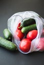 Reusable eco-friendly bag full of fresh seasonal tomatoes and cucumbers Royalty Free Stock Photo