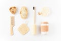 Reusable eco friendly items on white surface. Bamboo toothbrush, detangling hair brush, coffee mug, exfoliating loofah sponge Royalty Free Stock Photo