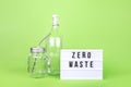 Reusable glass bottle and jar with metal straw and cinema lightbox on the light green drop Royalty Free Stock Photo